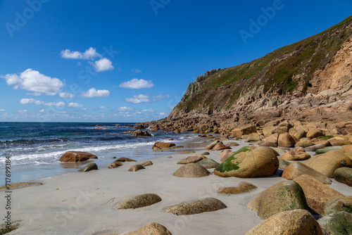 Rock formations on Porth Nanven beach on the Cornwall coast, with a blue sky overhead photo