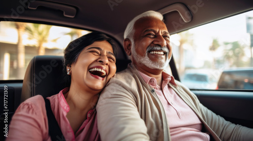 Happy senior couple of Indian ethnicity sitting inside a car and enjoying the trip