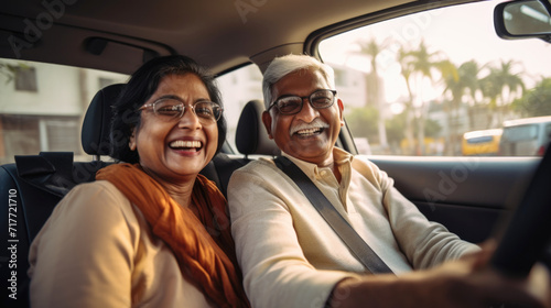 Happy  senior couple of Indian ethnicity sitting inside a car and enjoying the trip © AJay