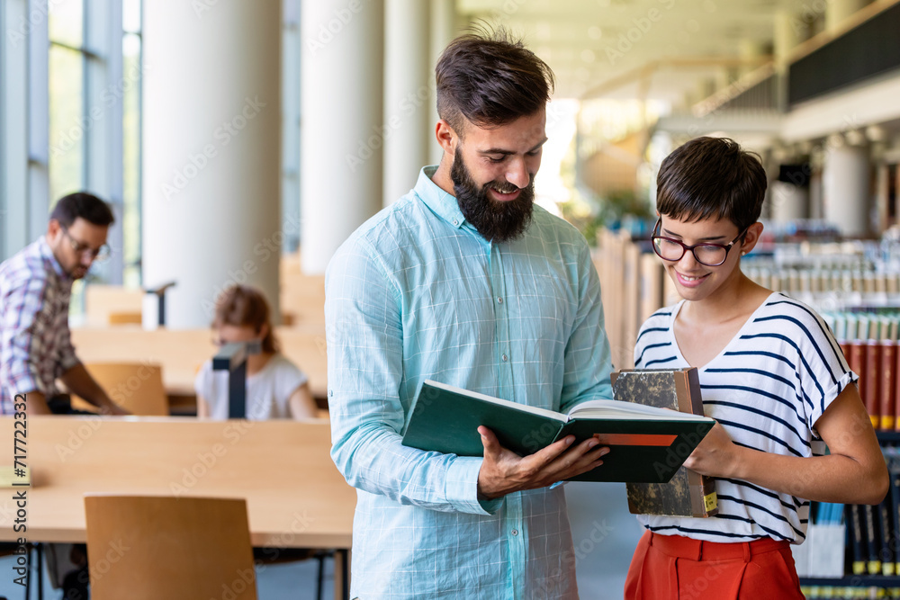 Happy university students studying with books in library. Group of multiracial people in college Happy university students studying with books in library. Group of multiracial people in college