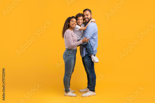 Happy black family with little son cuddling and smiling at camera © Prostock-studio