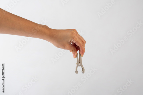 Close up of clothes peg in hand on white background