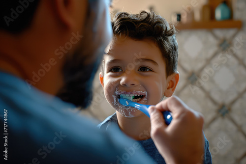 Father and son brush their teeth in the bathroom. Father teaches child to brush teeth.