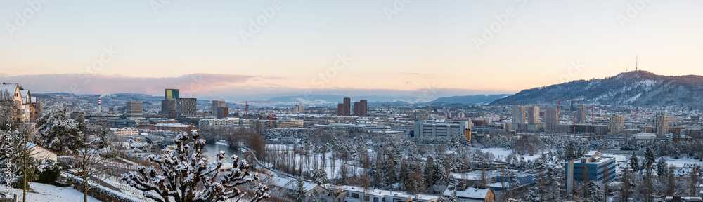 Snow covered Zurich or Zürich city. Top view panorama, rooftop POV, sunset sky, no people