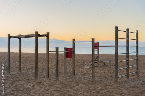 Photograph of a totally empty wooden calisthenics gym without people at sunrise next to the beach © Alberto Marrupe