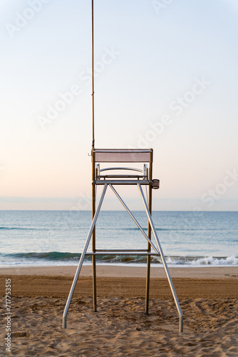 vertical image in the morning at dawn of a lifeguard surveillance post with no one sitting and with the beach without people
