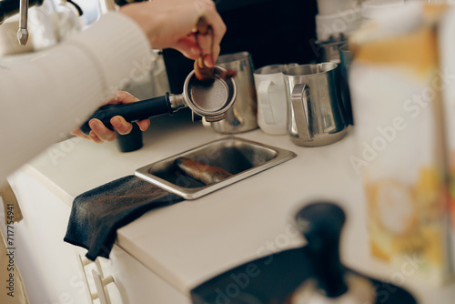 Close up of barista is cleaning and drying a filter holder after using. High quality photo