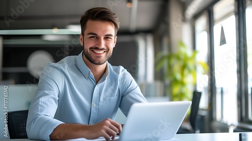 happy, smiling businessman using laptop in office