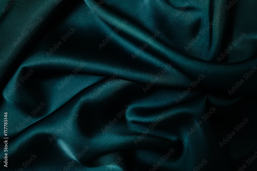 Fototapeta premium Emerald green silk or satin, draped fabric, elegant background.