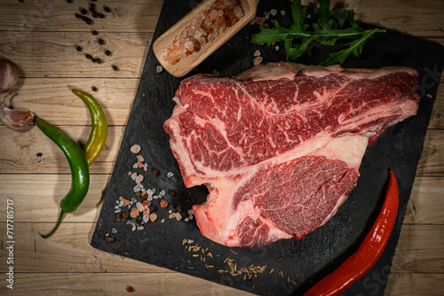 Fresh raw beef steak with spices and Himalaya salt on wooden rustic background top view. Healthy and organic food concept. photo