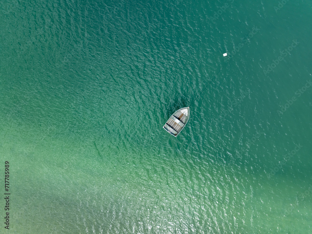 Aerial: Dinghy boat in thw water from above. Coromandel, Coromandel Peninsula, New Zealand.