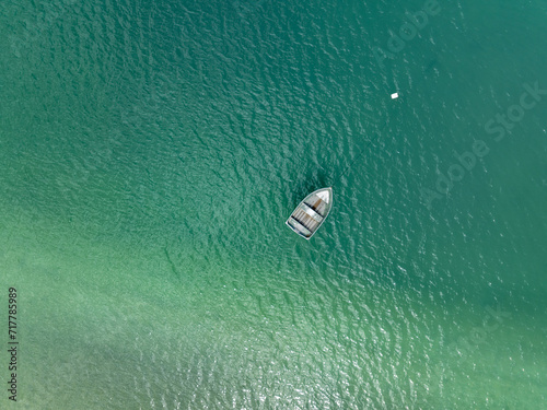 Aerial: Dinghy boat in thw water from above. Coromandel, Coromandel Peninsula, New Zealand.