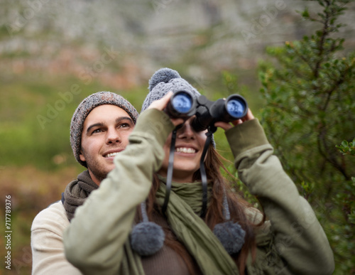 Couple, love and binocular in nature for travel, adventure or hiking journey and explore together in eco friendly mountains. Happy man and woman trekking with outdoor search, vision or birdwatching