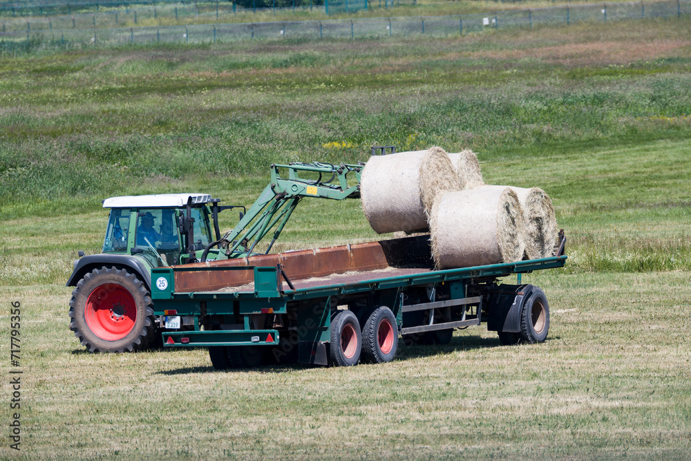 Fototapeta premium Bauer mit Traktor bei der Heuernte 