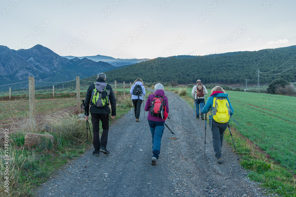 Hikers Walking on Rural Trail at Dusk