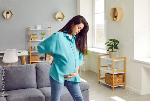 Foto Young pregnancy woman having labor contractions pain touching her tummy