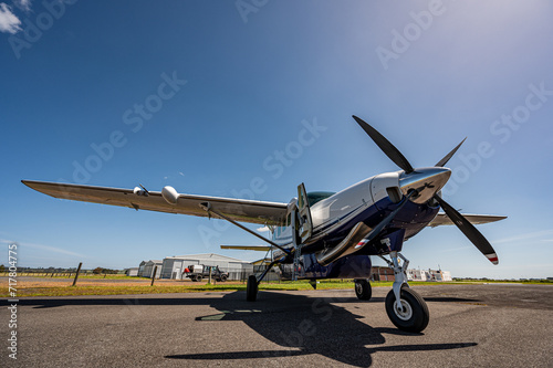 Light aircraft parked on tarmac wide angle