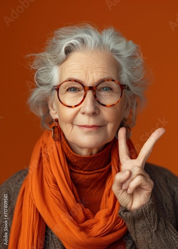 senior woman in glasses making a peace sign with a peace sign woman