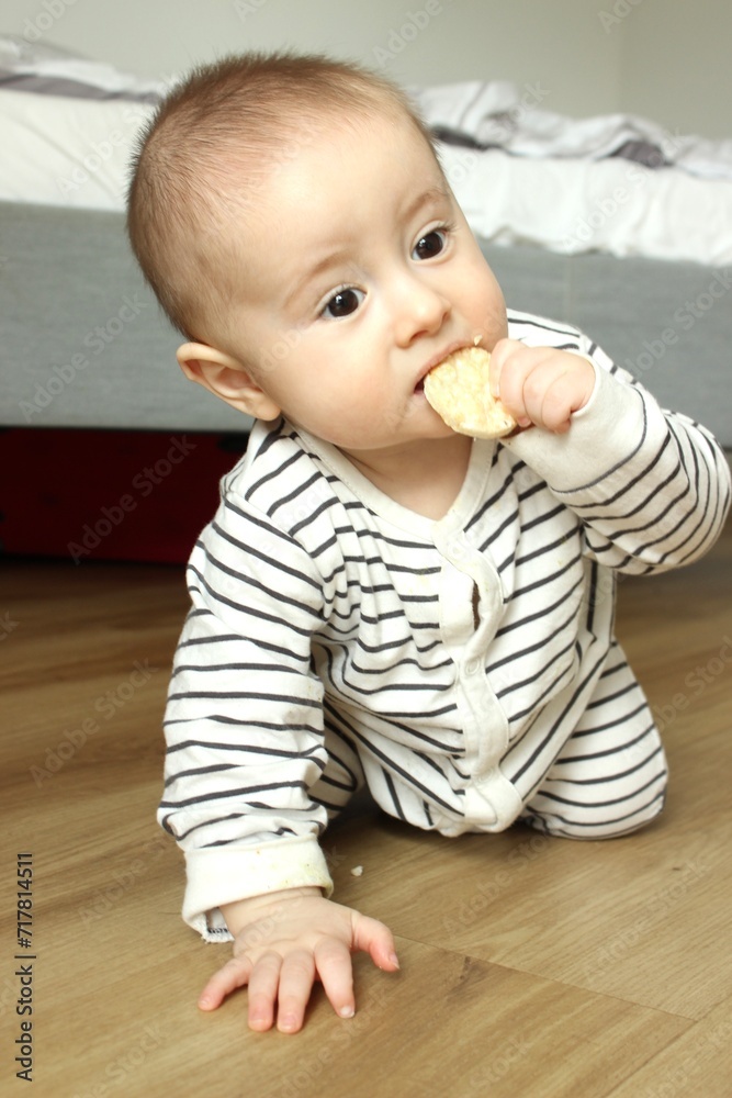Little baby boy crawls and eats on the go biting cookies Little baby boy crawls and eats on the go biting cookies