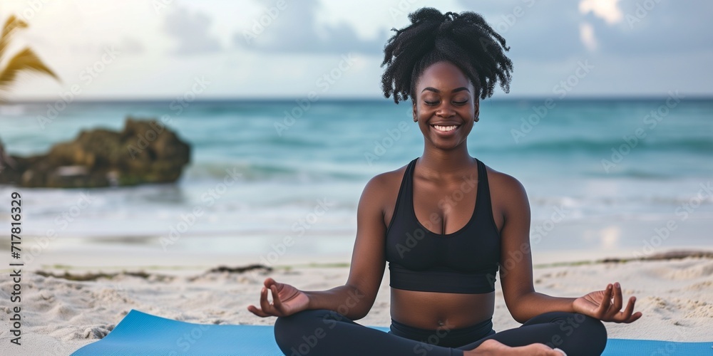 A woman in sportwear meditation at the beach