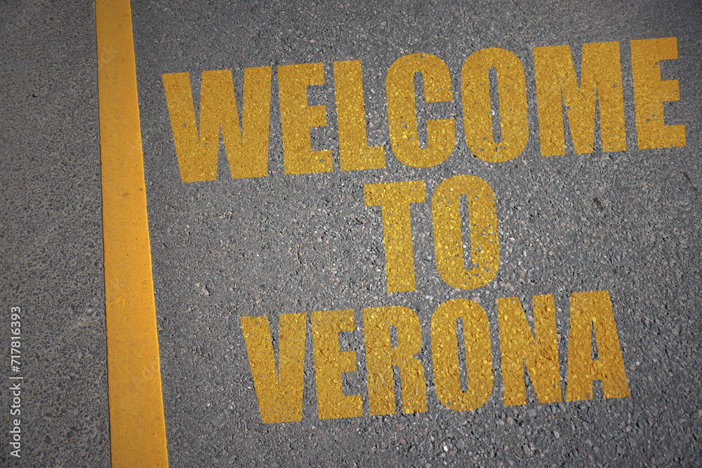 asphalt road with text welcome to Verona near yellow line.