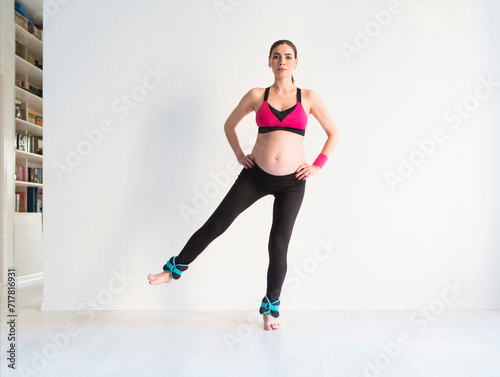 One young pregnant woman doing fitness exercises