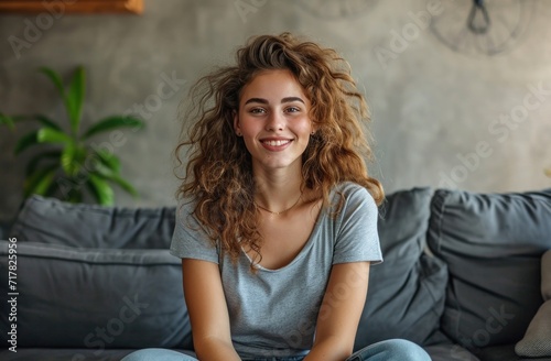 young woman sitting on an gray couch