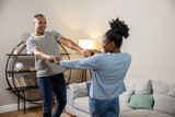 Man and woman having fun dancing while resting at home