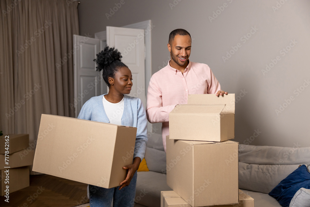 Man and woman relocating to a new house holding cardboard boxes with belongings Man and woman relocating to a new house holding cardboard boxes with belongings