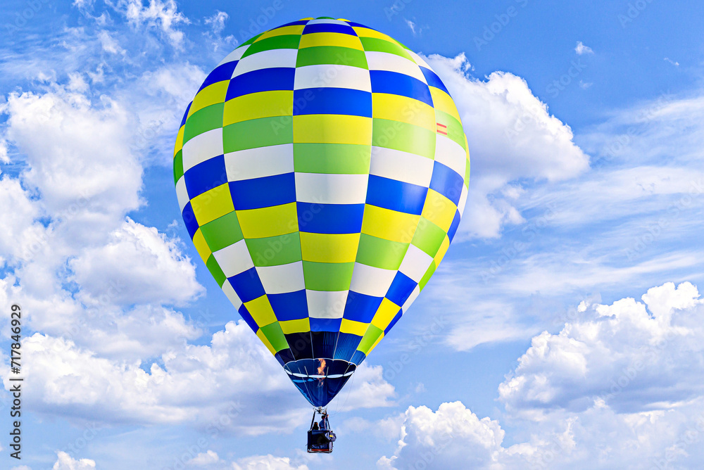 Fototapeta premium Colorful hot air balloon flying over blue sky with white clouds 