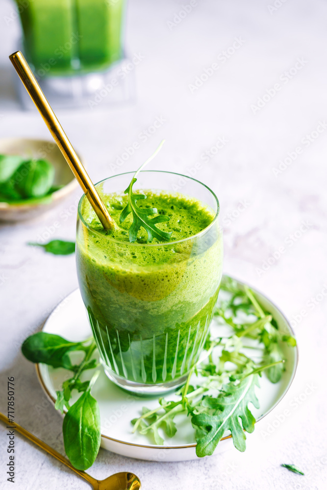 Ein grüner Smoothie in einem Trinkglas mit einem goldenen Strohhalm. Gesundes Frühstück. Ein grüner Smoothie in einem Trinkglas mit einem goldenen Strohhalm. Gesundes Frühstück.