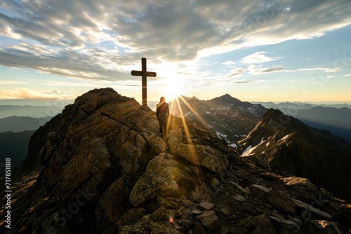 Wooden cross and man in the mountains against the background of a beautiful sky and sunlight