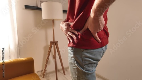 Man with hip, back and sciatica pain at home. photo
