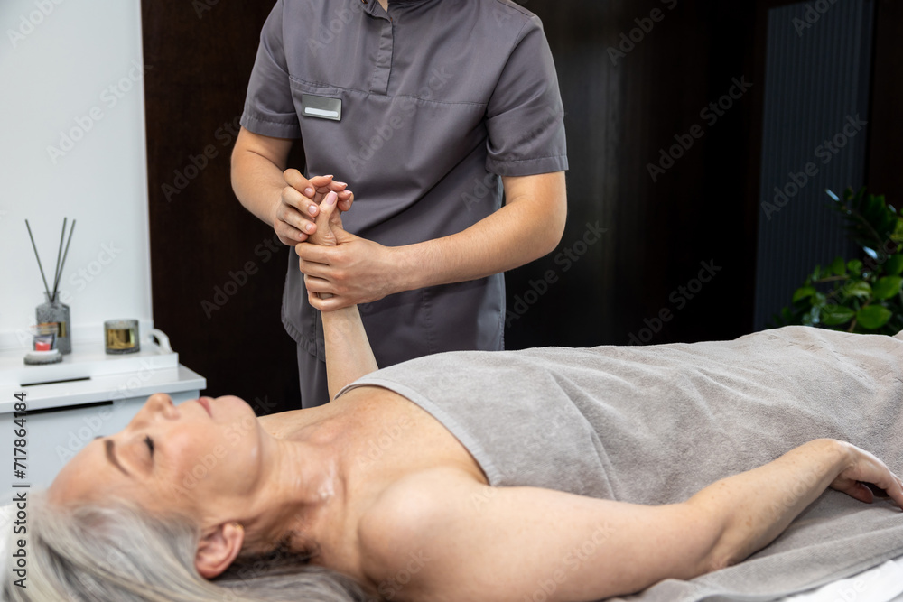 Male massage therapist doing hand massage to a female client Male massage therapist doing hand massage to a female client