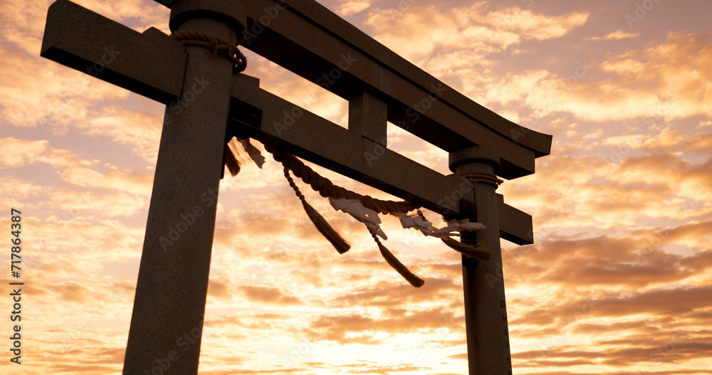 Torii gate, sunset and cloudy sky with zen, peace and spiritual history on travel adventure in Japan. Shinto architecture, Asian culture and calm nature on Japanese landscape with sacred monument.