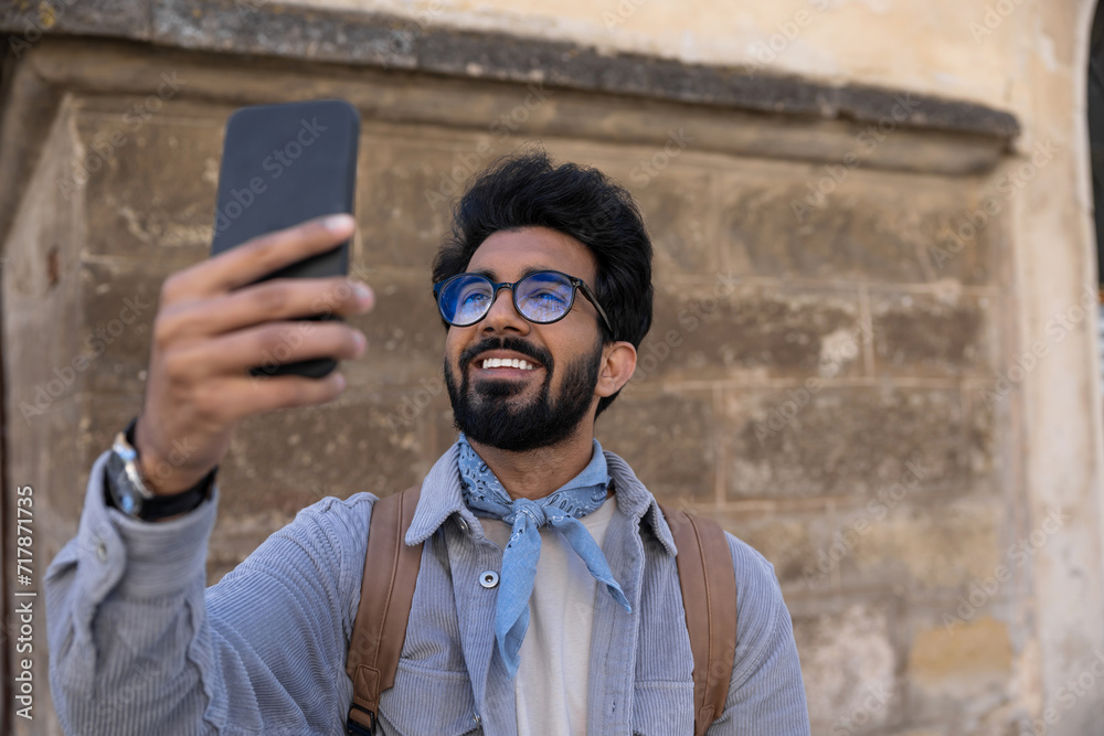 Smiling young man making pictures on a telephone Smiling young man making pictures on a telephone