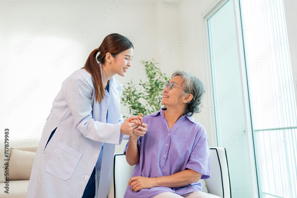 Obraz premium Asian female doctor taking care and talking mature female patient sitting on sofa in hospital. Healthcare concept.