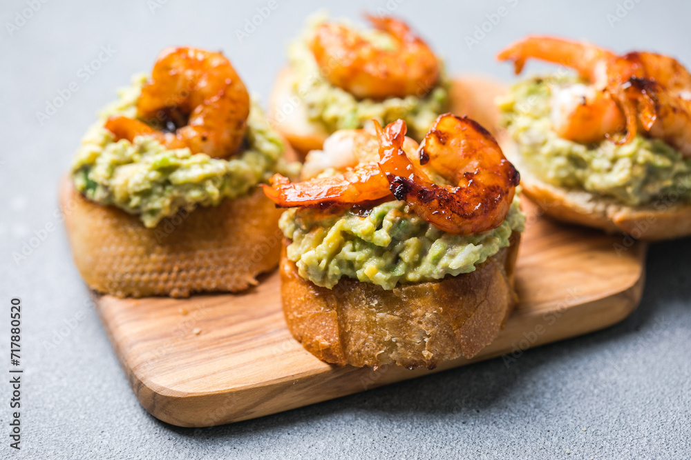Appetizer canape with shrimp on cutting board on table close up Appetizer canape with shrimp on cutting board on table close up
