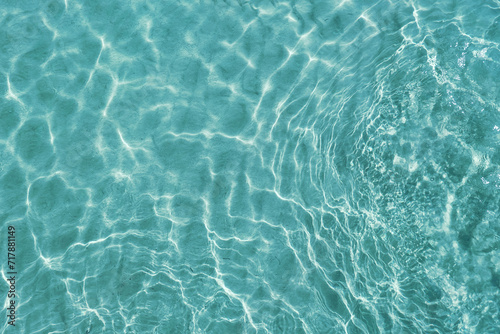Blue water surface viewed from above in outdoor sea, sun reflection, dimply. Surface Abstract Background. Clear water in sea with ripple in clean aqua liquid. Summer wallpaper blue background © SandyHappy