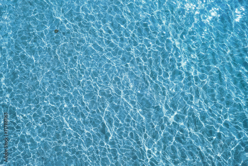 Blue water surface viewed from above in outdoor sea, sun reflection, dimply. Surface Abstract Background. Clear water in sea with ripple in clean aqua liquid. Summer wallpaper blue background