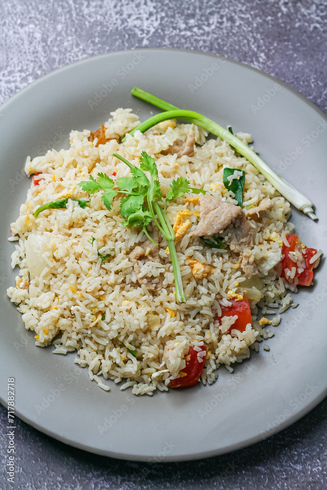 Fried rice with pork and vegetables in a plate on the table Fried rice with pork and vegetables in a plate on the table