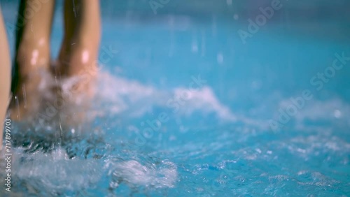 Detail from a synchronized swimming competition, legs out of the water photo