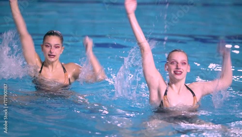 Synchronized swimming duet with two talented athletes execute a flawlessly coordinated routine, showcasing strength, agility, and perfect timing
