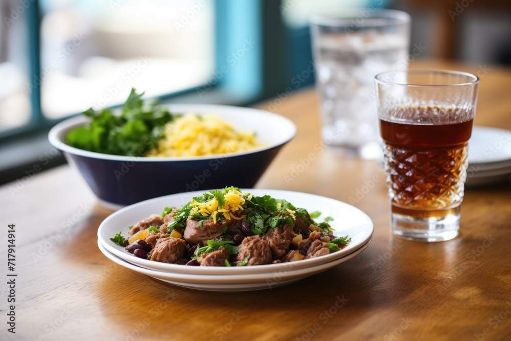 finished feijoada dish next to a cold glass of caipirinha finished feijoada dish next to a cold glass of caipirinha