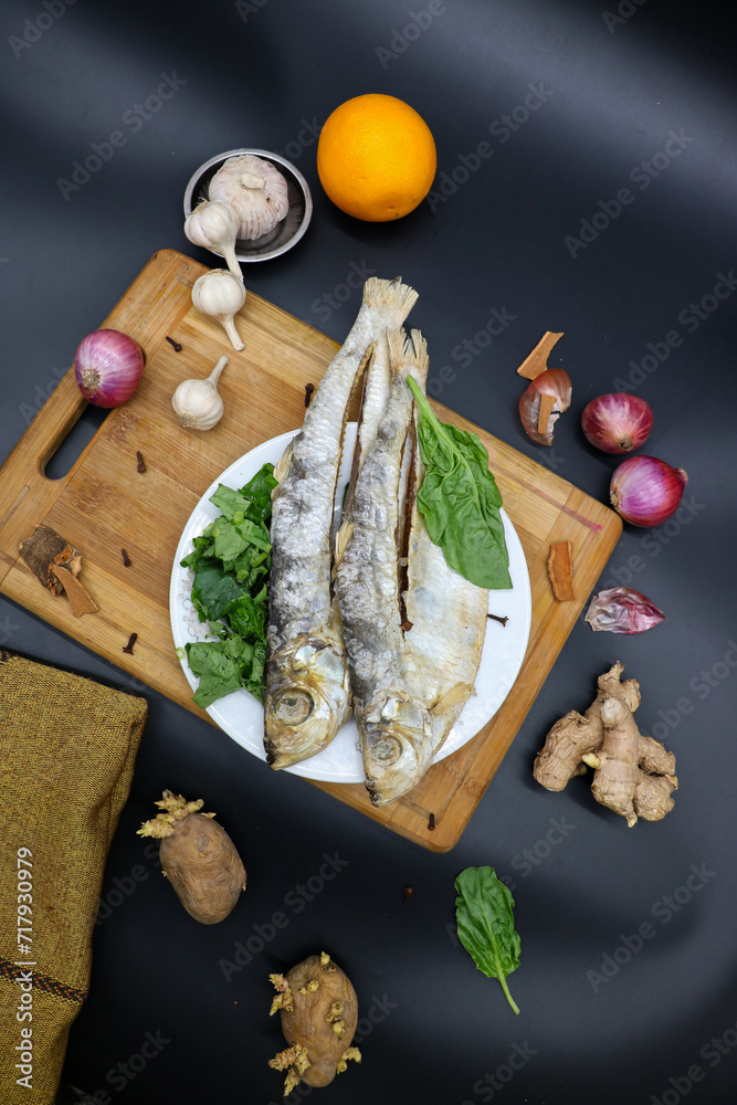 Dried fish black background, with green vegetable