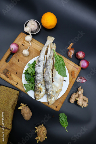 Obraz na płótnie Dried fish black background, with green vegetable w salonie