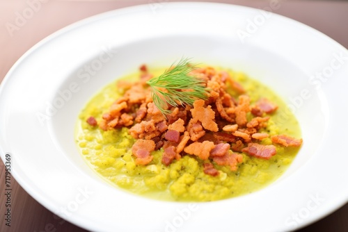 split pea soup with crumbled bacon on top, close up shot
