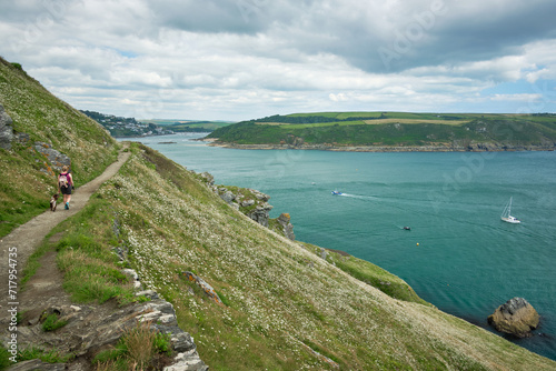 Hiker and dog approaching Salcombe from Bolt Head on the on the South West Coast Path, Devon, UK photo