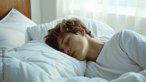 A young guy sleeps on a snow-white bed in his bedroom. World Sleep Day.