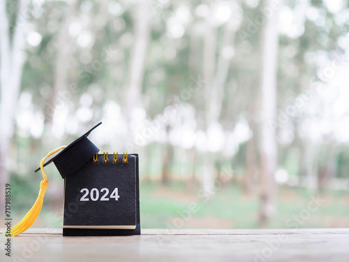 Study goals, 2024 Desk calendar with graduation hat. The concept for Resolution, Goal, Action, Planning, and manage time to success graduate.